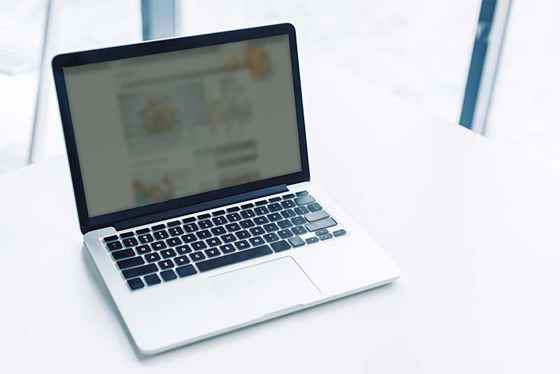 Laptop computer sitting on a white table.